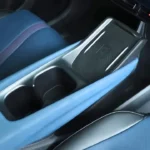 De BYD Dolphin Surf Comfort-uitvoering beschikt over een draadloze telefoonoplader (15W) in de middenconsole, samen met opbergruimte, bekerhouders en connectiviteitsopties inclusief USB-C en USB-A poorten voor gemak en organisatie.