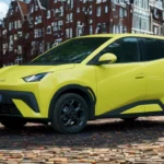 2025 BYD Dolphin Surf voorkant driekwart zicht met LED-koplampen, gesloten grille en 16-inch lichtmetalen velgen in stadsomgeving