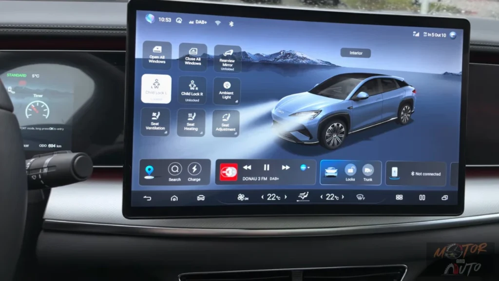 Het 15,6-inch centrale touchscreen display in de 2025 BYD Sealion 7 met het startscherm met pictogrammen voor voertuigbediening, klimaatregelingsinstellingen, mediabediening en een digitale weergave van het voertuig.