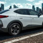 2025 CUPRA Tavascan achter driekwart aanzicht met LED-lichtbalk en sportief achterontwerp tegen stedelijke achtergrond