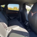 De 2025 CUPRA Tavascan's achterzitvlak toont comfortabele passagiersruimte, CUPRA driehoek logo accenten en premium bekleding in het familievriendelijke SUV interieur.
