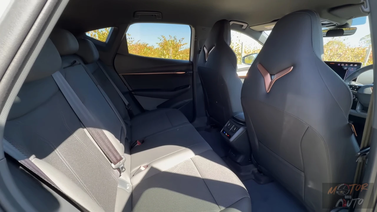 De 2025 CUPRA Tavascan's achterzitvlak toont comfortabele passagiersruimte, CUPRA driehoek logo accenten en premium bekleding in het familievriendelijke SUV interieur.
