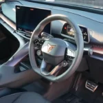 CUPRA Tavascan interieur met groot touchscreen, modern dashboard ontwerp met koperen accenten en premium materialen