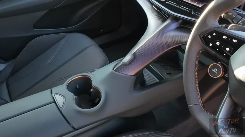 Close-up van de 2025 CUPRA Tavascan's onderscheidende centrale ruggengraat ontwerp met bekerhouders, opbergvakken en de kenmerkende getextureerde afwerking die de unieke cabine-ambiance creëert.