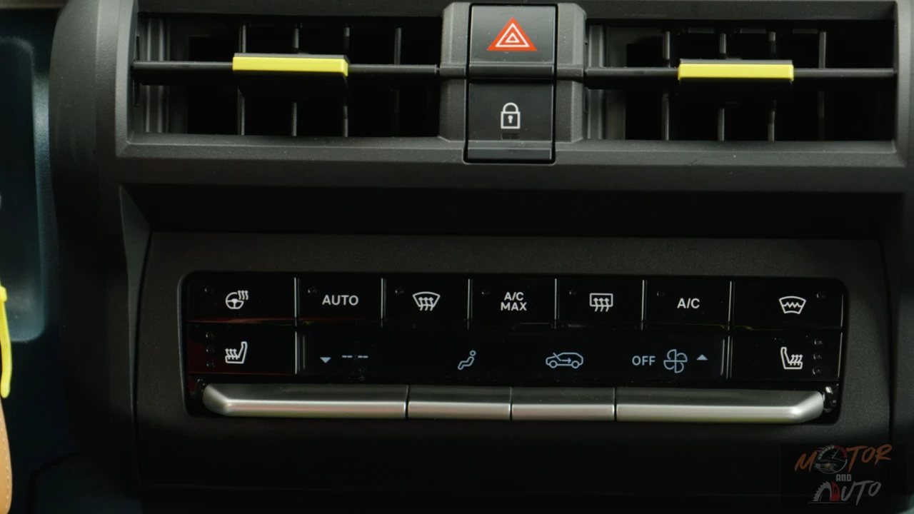 Automatische klimaatbeheersing van de 2025 Fiat Grande Panda E La Prima met fysieke knoppen voor automatische modus, A/C max, ontdooien en stoelverwarming, samen met waarschuwingsknipperlichten en centrale vergrendeling.