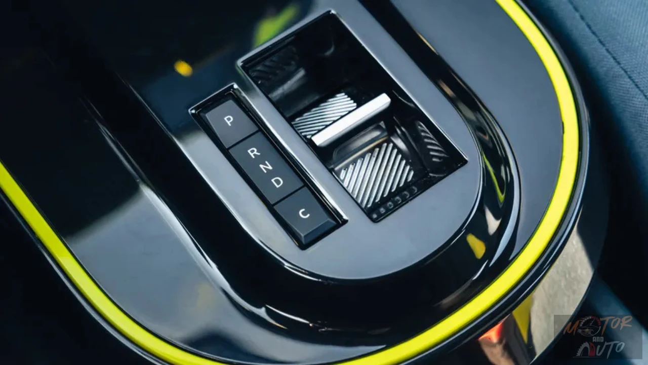 Gedetailleerd aanzicht van automatische versnellingspook met P-R-N-D-C posities, marmerpatroon opberggedeelte en gele accent trim