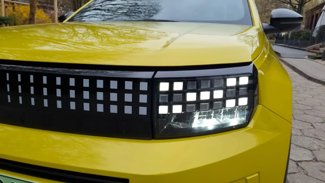 Close-up detail van het innovatieve gepixelde voorgrille-ontwerp van de 2025 Fiat Grande Panda E met geïntegreerde EcoLED-koplampen en LED-dagrijverlichting, dat Fiat's moderne elektrische voertuig ontwerptaal toont.
