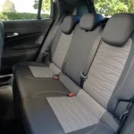 Achterbank zicht van 2025 Jeep Avenger interieur toont gewatteerde bekleding, hoofdsteunen en passagiersruimte in compact cabine ontwerp