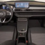 Volledig interieur zicht van 2025 Jeep Avenger cabine toont voor- en achterbank, middenconsole met draadloos opladen en dashboard configuratie