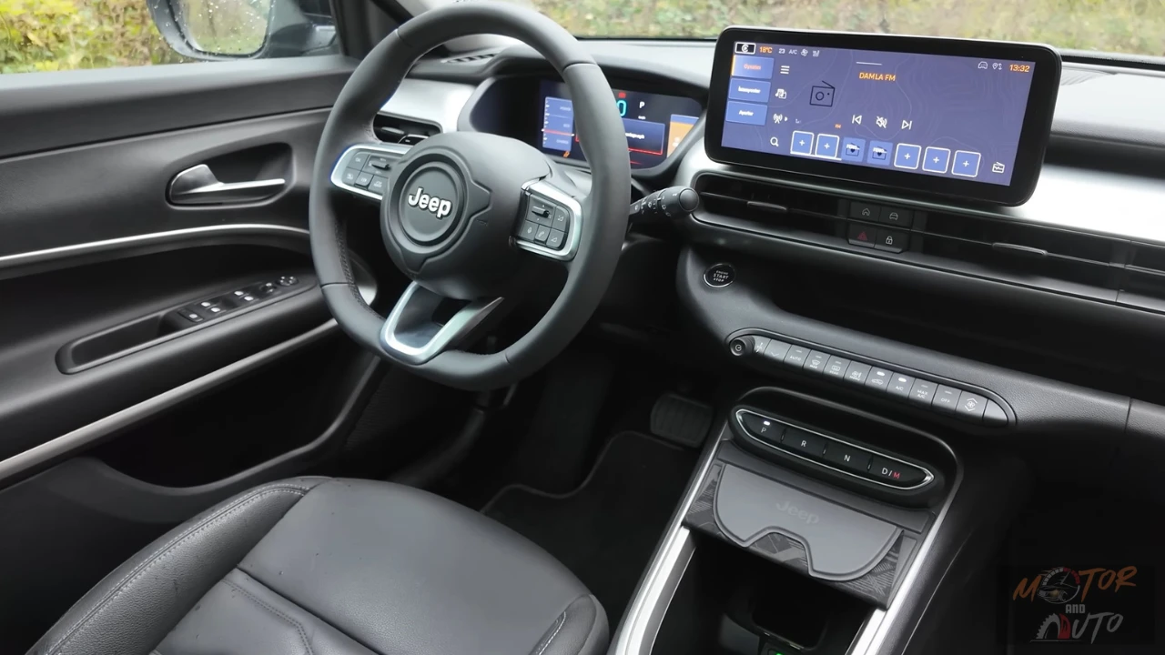 Interieur zicht toont 2025 Jeep Avenger infotainment touchscreen met moderne interface, fysieke klimaatregeling en stuurwiel