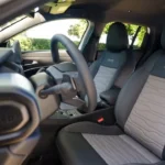 Gedetailleerde opname van 2025 Jeep Avenger stoel toont gewatteerde leren bekleding patroon en Jeep logo geborduurd in hoofdsteun
