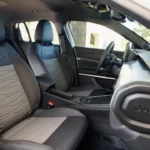 Close-up van 2025 Jeep Avenger voorstoelen toont gewatteerd bekledingspatroon, Jeep logo borduurwerk en premium materiaalcombinatie