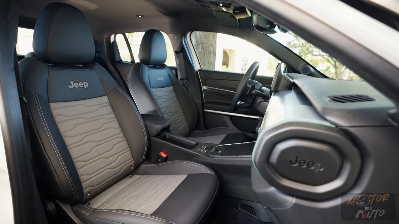 Close-up van 2025 Jeep Avenger voorstoelen toont gewatteerd bekledingspatroon, Jeep logo borduurwerk en premium materiaalcombinatie