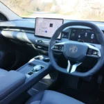 Interieur dashboardweergave van de 2025 MG S5 EV met het grote centrale touchscreen, digitaal instrumentenpaneel, en modern strak ontwerp met grijze bekleding.