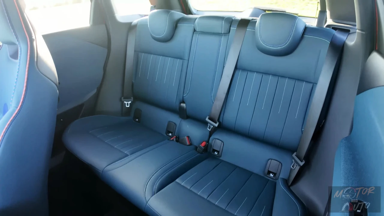 Mini Aceman achterbank in blauw gewatteerd leer met contrasterende stiksels, drie veiligheidsgordels, en ISOFIX kinderzitje bevestigingspunten