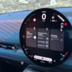 Close-up van het innovatieve circulaire OLED-touchscreen van de 2025 Mini Aceman met verschillende menu-opties, laadstatus en voertuiginstellingen interface