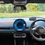 Uitgebreid zicht op het dashboard van de 2025 Mini Aceman met het circulaire OLED-display, gebreide stoffen oppervlakken en tuimelschakelaar bedieningselementen