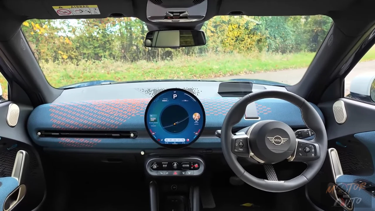 Uitgebreid zicht op het dashboard van de 2025 Mini Aceman met het circulaire OLED-display, gebreide stoffen oppervlakken en tuimelschakelaar bedieningselementen