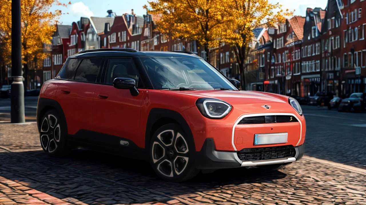 Rode Mini Aceman elektrische SUV gefotografeerd in warme gouden uur verlichting met voorste driekwart zicht met LED-koplampen, crossover carrosseriestijl en herfst stedelijke achtergrond