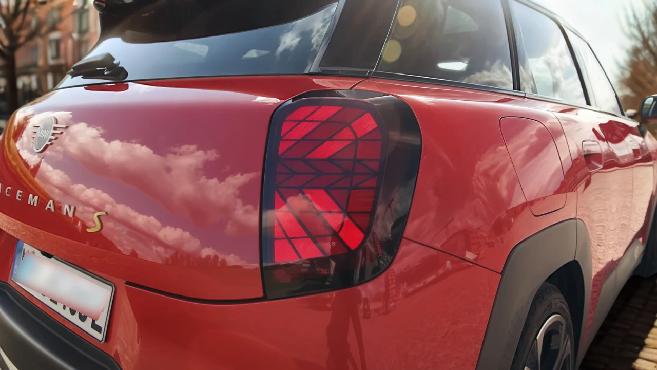 Gedetailleerd zicht van Mini Aceman achterlicht met verlicht Union Jack geometrisch LED-patroon in rode behuizing met ACEMAN badge letters en gele S elektrische aanduiding