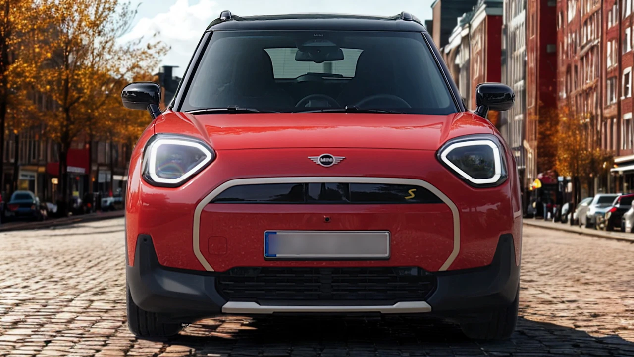 Vooraanzicht van rode Mini Aceman elektrische crossover met gesloten paneel grille, hoekige LED-koplampen met witte DRL, Mini-badge en geel "S" elektrisch symbool op Europese herfststraat