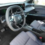 Bestuurderszicht van het interieur van de 2025 Renault 4 E-Tech Electric met digitale cockpit en moderne bedieningselementen
