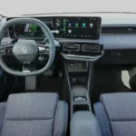 Volledig dashboardaanzicht van de 2025 Renault 4 E-Tech Electric met de dubbele 10-inch displays, kenmerkende blauwe interieurbekleding en modern design