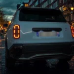 Detailopname van de verlichte driedelige LED-achterlichten van de 2025 Renault 4 E-Tech Electric in het donker met hun unieke lichtsignatuur