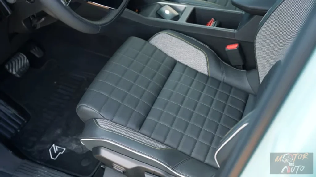 Close-up van de bestuurdersstoel van de 2025 Renault 4 E-Tech Electric met doorgestikt grijs kunstleder met stoffen middensectie en contrasterende stiksels