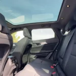 Uitgebreid zicht op de achter cabine van de 2025 Renault Austral benadrukt de royale ruimte, panoramisch glazen dak en premium interieur materialen overal.