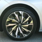 Close-up detail van 2025 Škoda Enyaq 20-inch zwart metallic lichtmetalen velg met multi-spaaks ontwerp en Škoda centrumkap