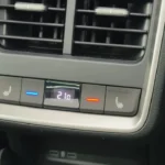 Close-up van 2025 Škoda Enyaq achter klimaatregeling paneel met temperatuurweergave van 21 graden, verwarmde stoelregeling en luchtroosters erboven
