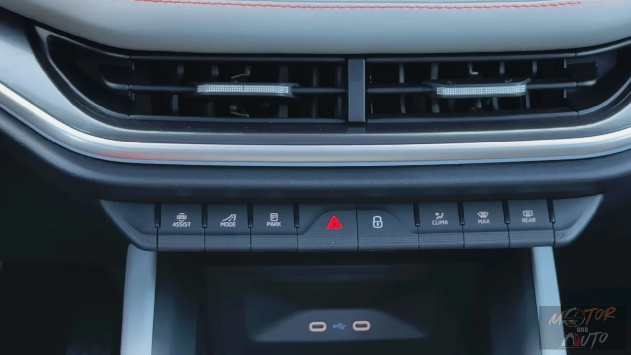 Close-up van 2025 Škoda Enyaq middenconsole met rij bedieningsknoppen inclusief Assist, Mode, Park, waarschuwingslichten en andere voertuigfunctie knoppen