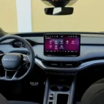 Breed interieurzicht van 2025 Škoda Enyaq met complete dashboard, stoelen en ruime cabine met groot infotainment scherm en modern ontwerp