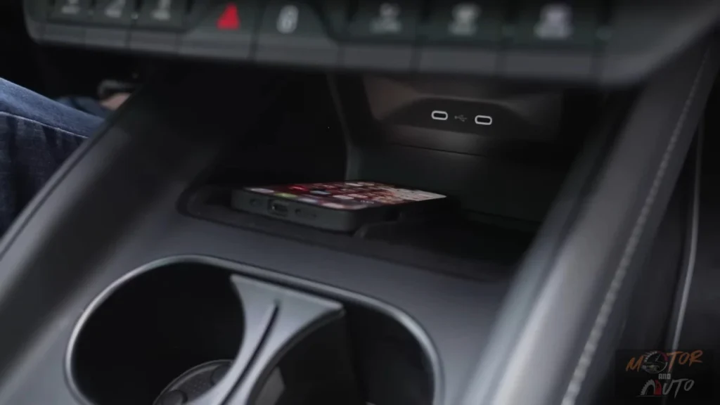 Detailbeeld van 2025 Škoda Enyaq draadloze oplaadzone in middenconsole met smartphone plaatsingszone en dubbele ovale oplaad indicatoren
