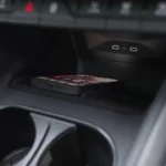 Detailbeeld van 2025 Škoda Enyaq draadloze oplaadzone in middenconsole met smartphone plaatsingszone en dubbele ovale oplaad indicatoren