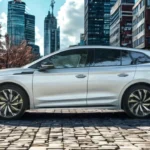 2025 Škoda Enyaq elektrische SUV zijprofiel in wit met complete voertuigverhoudingen en grote lichtmetalen velgen op kinderkopjes straat met herfstbomen en stedelijke gebouwen