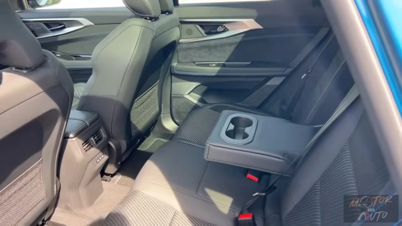 Achter zitgebied van de 2025 Renault Austral met middenconsole met bekerhouders, neerklapbare armsteun en comfortabele zitconfiguratie.