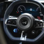 Het motorsportgeïnspireerde stuurwiel van de Alpine A390 heeft de kenmerkende rode 'OV' (Overtake) knop en blauwe 'RCH' (Recharge) draaiknop, wat Formule 1 technologie naar gezinsrijden brengt.