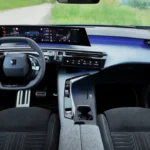 Compleet dashboard overzicht van 2025 Peugeot E-3008 Dual Motor met stof trim, gebogen display en blauwe sfeerverlichting