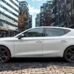 Zijprofiel zicht van witte 2025 Cupra Leon hatchback met atletische proporties