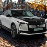 2025 DS N°8 elektrische luxe crossover in wit en zwart twee-tonen lak op kinderkopjes straat met verlichte voortgrille en modern ontwerp