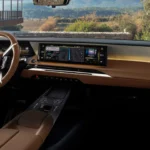 Interieurzicht van 2025 DS N°8 met dashboard, groot touchscreen, bruin lederen stuurwiel, stoelen en aluminium trim details