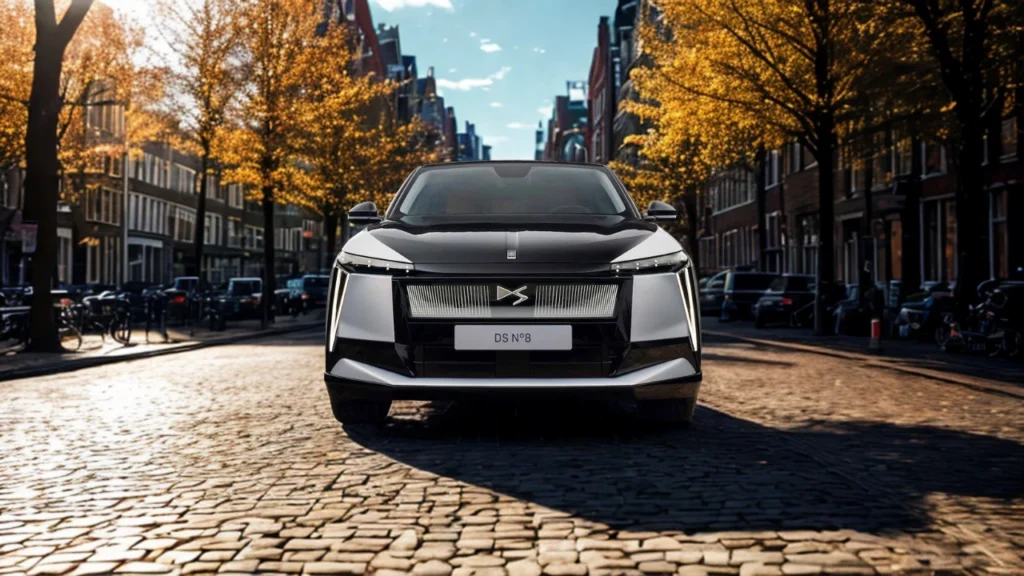 Frontaal zicht van 2025 DS N°8 met verlichte voorgrille met DS logo en moderne LED koplamp ontwerp op historische straat