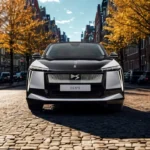 Frontaal zicht van 2025 DS N°8 met verlichte voorgrille met DS logo en moderne LED koplamp ontwerp op historische straat