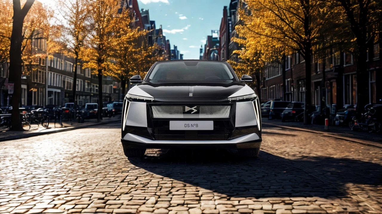 Frontaal zicht van 2025 DS N°8 met verlichte voorgrille met DS logo en moderne LED koplamp ontwerp op historische straat