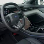 Dashboard en stuurwieloverzicht van de 2025 Ford Capri met modern interieurontwerp met digitale displays en carbon fiber afwerking