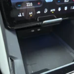 Verborgen opbergvak onder het beweegbare touchscreen in het interieur van de 2025 Ford Capri