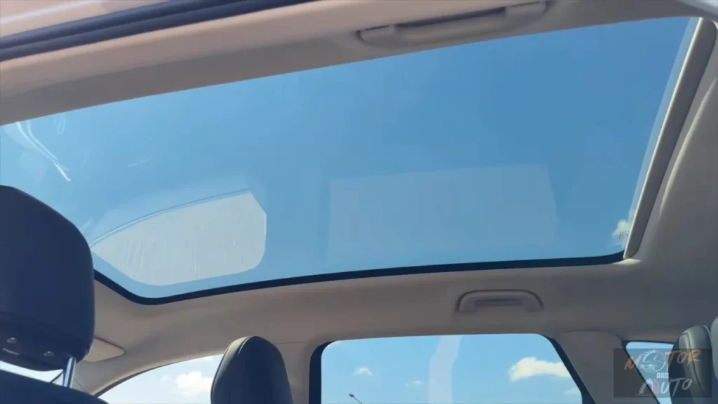 Interieur omhoog zicht van 2025 Leapmotor C10 REEV met groot panoramisch glazen dak opening met heldere lucht zichtbaar en dakpaneel structuur voor heldere, ruime cabine atmosfeer.
