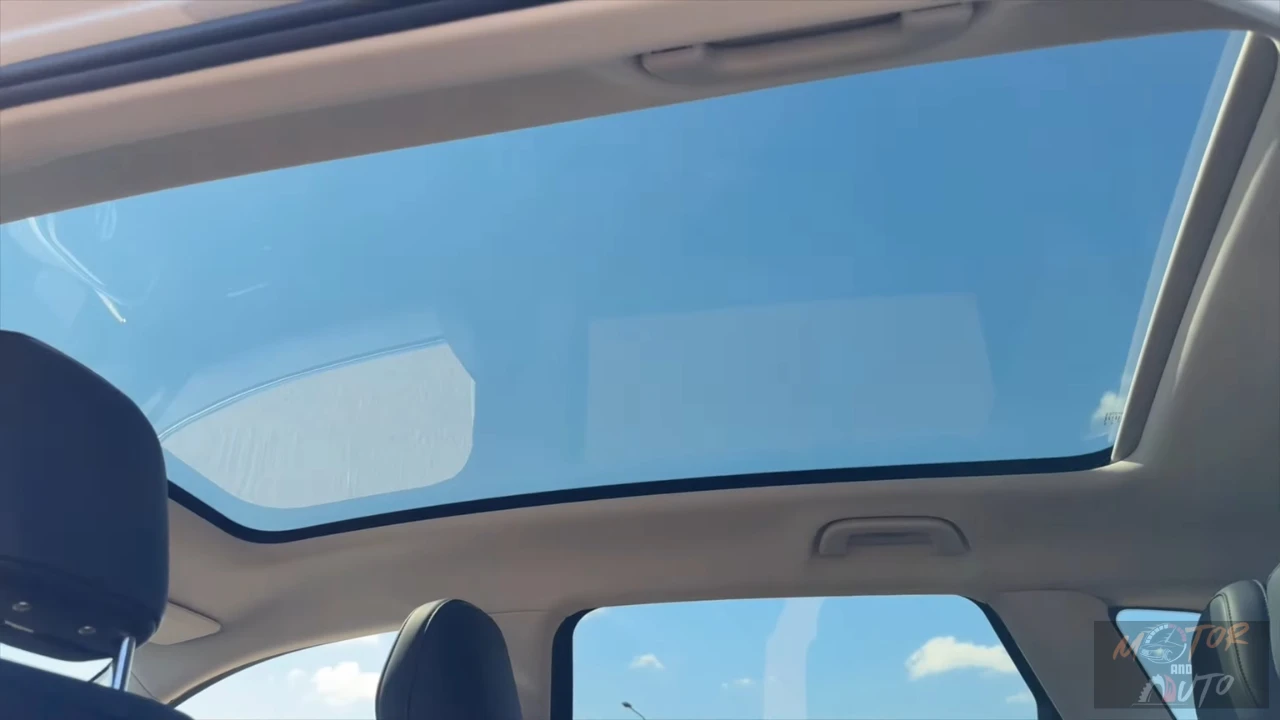 Interieur omhoog zicht van 2025 Leapmotor C10 REEV met groot panoramisch glazen dak opening met heldere lucht zichtbaar en dakpaneel structuur voor heldere, ruime cabine atmosfeer.